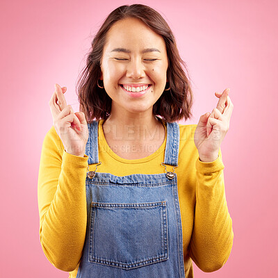 Buy stock photo Asian, woman and fingers crossed for hope in studio, pink background or praying for luck. Happy model wish with hands for bonus, promotion or winning giveaway for emoji, competition prize and lottery