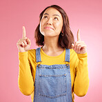 Smile, pointing and happy young woman in a studio for marketing, promotion or advertising. Happiness, confident and Asian female model with presentation finger gesture isolated by a pink background.