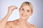 Skincare, oil and portrait of woman in studio for liquid, application and dermatology treatment on grey background. Face, serum and female wellness model with vitamin c, retinol or hyaluronic acid