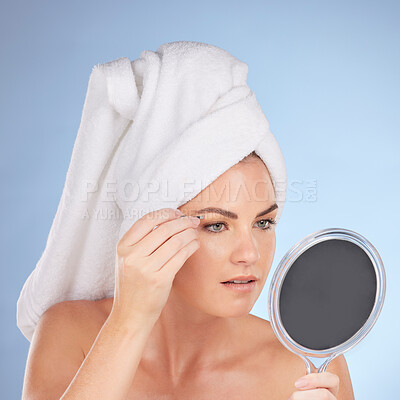 Buy stock photo Beauty, woman and mirror with tweezers for eyebrow in studio, blue background or aesthetic change. Face of female model, epilation tools and hair removal for grooming brows, facial skincare or shower