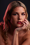 Portrait, beauty and lipstick with a model woman in studio on a dark background in red lighting for desire. Face, skincare or makeup with a young female person posing for natural feminine confidence