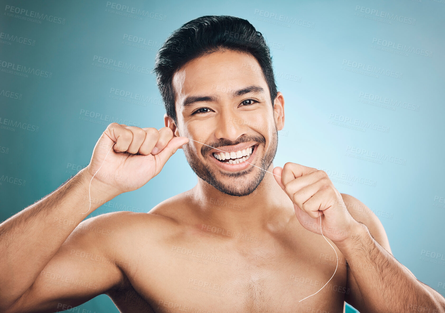 Buy stock photo Wellness, teeth and dental floss of a man portrait with cleaning and dental health in a studio. Face, blue background and healthy male person with flossing for mouth hygiene and healthcare with smile