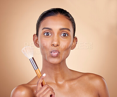 Buy stock photo Kiss, makeup and brush with portrait of woman in studio for beauty, foundation and self care. Cosmetics, product and tools with face of model on brown background for glow, skincare and dermatology