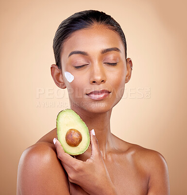 Buy stock photo Avocado, cream and skincare with face of woman in studio for product, beauty and natural cosmetics. Spa, facial and lotion with female model on brown background for vitamin c, fruit and self care