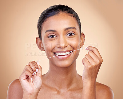 Buy stock photo Woman, mouth and flossing in studio portrait with smile, cleaning or teeth whitening by brown background. Girl, model and happy for dentistry product, string or self care for tooth, beauty or health