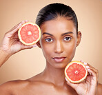 Grapefruit, portrait and beauty of woman in studio for vitamin c benefits, eco cosmetics and nutrition. Face of indian female model, natural skincare and healthy citrus food for aesthetic dermatology