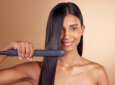 Buy stock photo Portrait, hair and straightener with a model woman in studio on a beige background for beauty or style. Face, smile and haircare with happy young person using a flat iron appliance for natural care