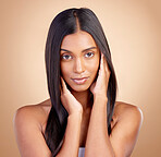 Portrait, hair care and Indian woman with beauty, makeup and dermatology on a brown studio background. Face, female person and model with volume, texture and scalp treatment with aesthetic and luxury