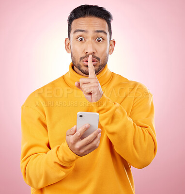 Buy stock photo Man, phone and studio with finger, silence and sign language for secret promotion by pink background. Gen z guy, student or fashion model with smartphone, hand and lips for portrait, deal and sale