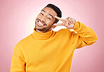 Smile, peace sign and portrait of man in studio for support, kindness and happy. Emoji, happiness and thank you with face of person on pink background for mindfulness, vote and v hand gesture