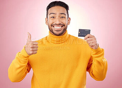 Buy stock photo Man, thumbs up and credit card with finance, payment and loan, budget and fashion sale on studio pink background. Portrait, banking success and asian person or gen z for e commerce or shopping emoji