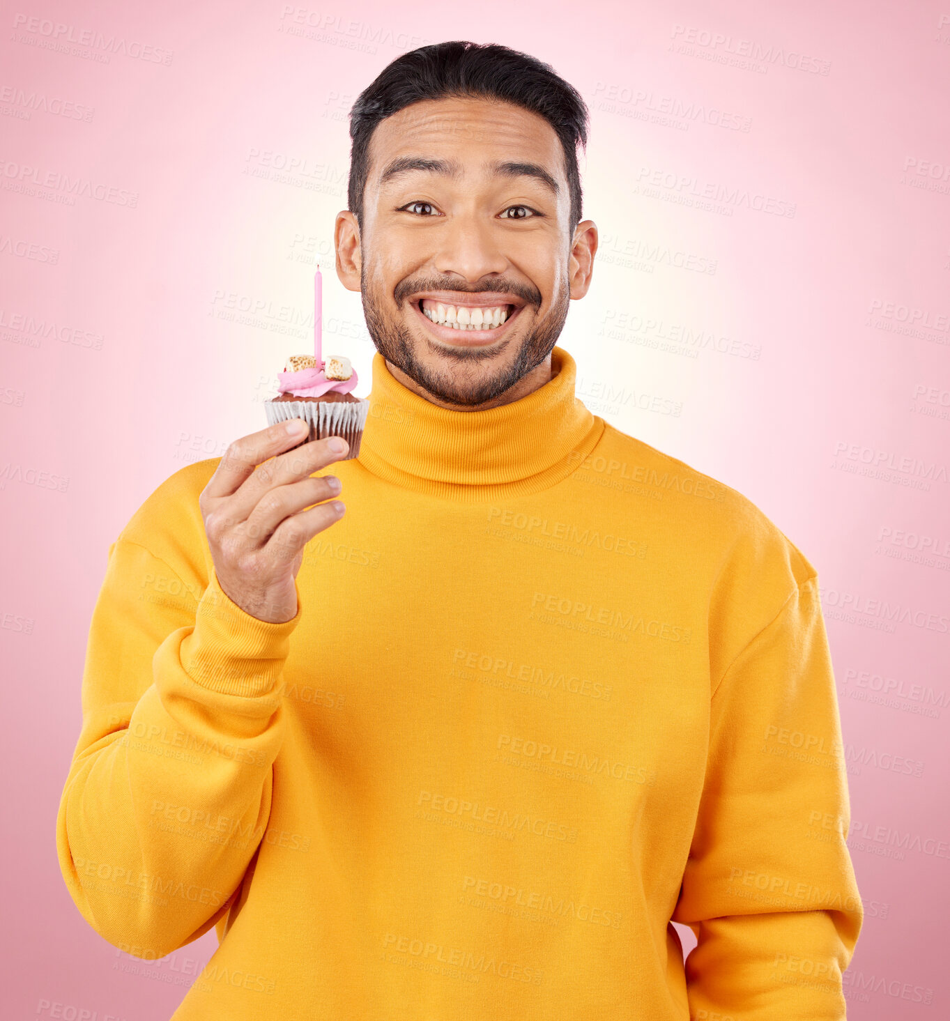 Buy stock photo Man, portrait and cupcake for birthday, celebration and winner, success or achievement on pink background. Excited, happy and young asian person with candle and cake for winning competition in studio