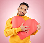 Heart, poster and love with portrait of man in studio for romance, date and valentines day. Kindness, support and hope with person and sign on pink background for wellness, peace and creative mockup