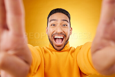 Buy stock photo Funny, portrait and selfie of excited man in studio isolated on a yellow background. Face, smile and Asian person taking profile picture for happy memory, laughing and photography on social media