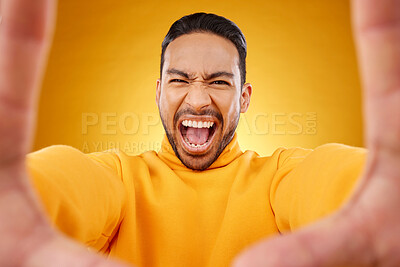 Buy stock photo Screaming, portrait and selfie of angry man in studio isolated on a yellow background. Face, shouting and Asian person taking profile picture for memory in anger, frustrated or stress for problem