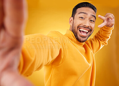 Buy stock photo Peace sign, selfie and happy portrait of a man in studio with a hand, emoji and a smile. Male asian fashion model excited on a yellow background with a positive icon for social media profile picture