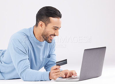 Buy stock photo Laptop, credit card and happy asian man on studio floor for ecommerce, sale or cashback on grey background. Online shopping, deal and Japanese male customer smile for loan, payment or sign up promo