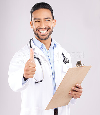 Buy stock photo Happy asian man, doctor and portrait with thumbs up for healthcare approval against a grey studio background. Male person or medical expert smile with clipboard, like emoji or yes sign for success