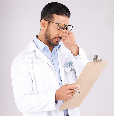 Buy stock photo Stress, checklist and man doctor in a studio for a medical diagnosis or wellness treatment. Burnout, headache and male healthcare worker with a migraine for clipboard isolated by a gray background.