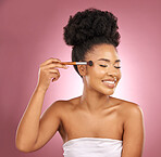 Makeup, smile and black woman with brushes, beauty and dermatology against a pink studio background. Female person, skincare or happy model with cosmetic tools,  aesthetic and grooming with self care