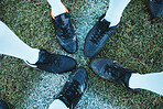 Soccer, sport shoes and teamwork with people together on a grass field for motivation or competition. Closeup, above and football player or athlete group on a pitch for training, exercise or fitness 