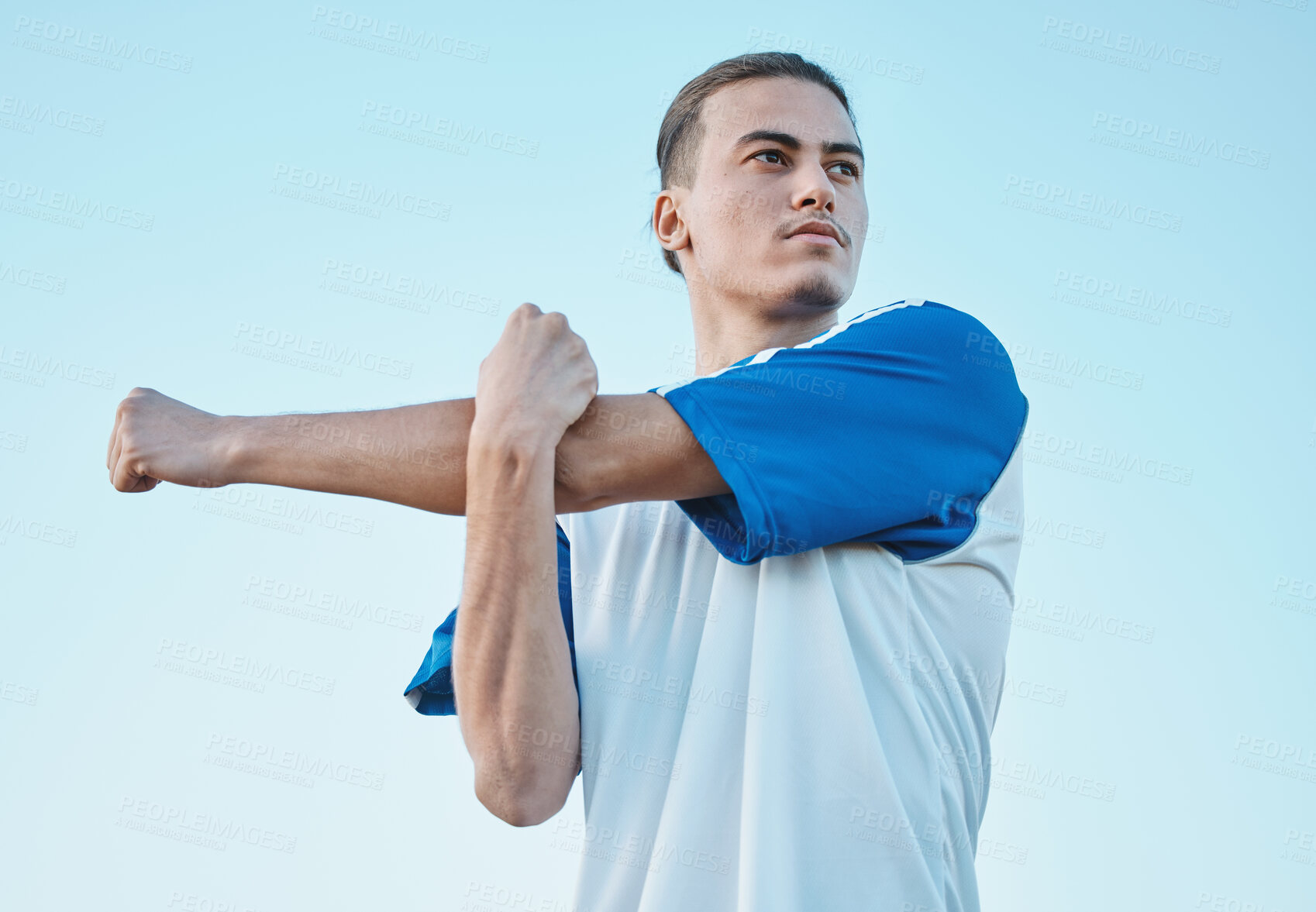 Buy stock photo Soccer, stretching and a sports man on a blue sky background in preparation for a game or competition. Fitness, health and warm up with a young male athlete getting ready for training or practice