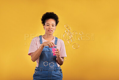 Buy stock photo Woman, blowing bubbles and fun portrait in studio while playful for birthday, space or party celebration. Black female model person with liquid soap, natural beauty and fashion on a yellow background