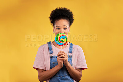 Buy stock photo Portrait, black woman with candy or lollipop in studio on yellow background and eating sweets, dessert or food with sugar. Gen z, face of girl and hungry for delicious treats, snack or product