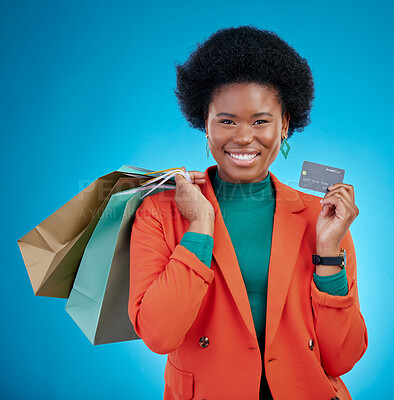 Buy stock photo Credit card, shopping bag and woman in portrait for retail banking, finance and e commerce fintech or payment. Happy customer, fashion model or african person for debit pay on blue, studio background