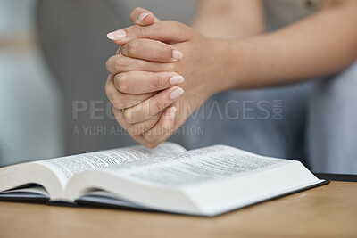 Woman hands, bible book and prayer in home of spiritual faith, holy gospel and worship of God. Closeup female person praying with christian books, studying religion or praise of jesus christ in peace