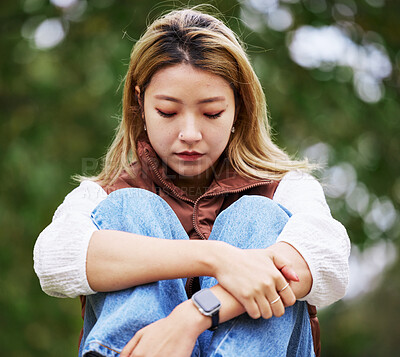 Buy stock photo Student, depression and thinking with woman in park for sad, college and anxiety. Mental health, psychology and burnout with asian person feeling lonely in nature for fatigue, pain and problem