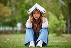 Study, stress and book with woman in park for studying, thinking and depression. College, mental health and education with asian student on grass in nature for burnout, anxiety and fatigue problem