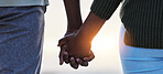 Holding hands, couple and love outdoor at the beach with care, trust and commitment. Closeup of a man and woman relax together on vacation, holiday or sunset travel adventure in nature for freedom