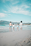 Family is walking on beach, hand holding and back view, ocean and bonding on holiday, freedom and travel. Parents, young children and solidarity on tropical vacation in Mexico, love and care outdoor