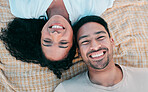 Portrait, picnic and smile with a couple on a blanket from above, lying down on the ground while on a date. Face, love or happy with a man and woman bonding together for romance on valentines day