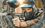 Paintball, shooting and man in action with gun for tournament, competition and battle in nature. Camouflage, military and male person aim in outdoor arena for training, adventure game or challenge