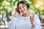 Outdoor, music and woman with headphones, listening and streaming audio with happiness, stress relief and dance. Female person, radio and happy girl with a headset, smile and online sounds in a park