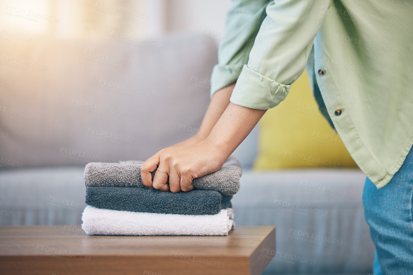 Buy stock photo Hands, home and laundry on living room table for hygiene, cleaning and folding for housework in morning. Woman, fabric and cotton towel on desk for organized house, service and routine in apartment