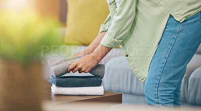 Buy stock photo Hands, home and fold laundry on table for hygiene, cleaning and soft clothes for housework in living room. Woman, fabric and cotton towel on desk for organized house, service and routine in apartment