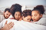 Family, sleeping and together in bed at home for security, bonding and comfort. Healthy, mixed race and a man, woman and children nap, dream and rest or relax in a bedroom with love, care and peace