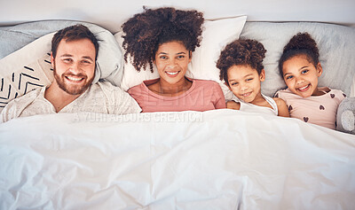Buy stock photo Family, happy and portrait in bed at home for quality time, bonding or morning routine. Above, mixed race and smile of a man, woman and children together in a bedroom with love, care and comfort