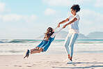 Spinning, mother and a child happy at the beach while on a family vacation, holiday or adventure. A young woman or mom and girl kid playing together while outdoor for summer fun and travel in nature