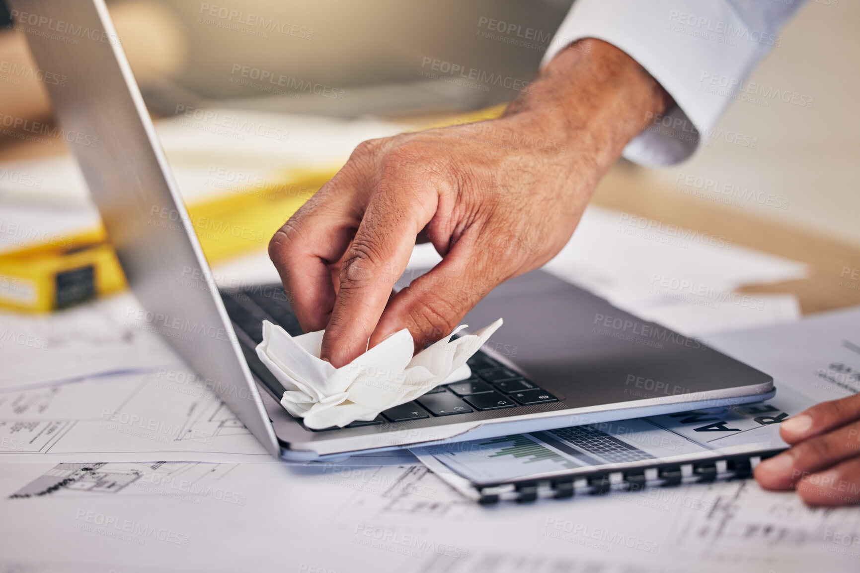 Buy stock photo Hand with cloth, keyboard on laptop and cleaning dust or dirt from workspace with blueprint and architecture. Wiping, tissue and engineer with computer cleaner for safety care, caution and paperwork.