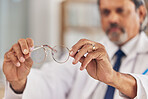 Optometrist, man and glasses in hand for vision or eyesight or prescription lens for worker. Doctor, closeup and frames in workplace with eyewear for wellness or focus with medical expert for care.
