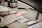 Hands, business person and red wrist pain at computer for osteoporosis, orthopedic injury and health risk. Closeup of worker, carpal tunnel and glow of muscle problem in stress, fibromyalgia or sepia