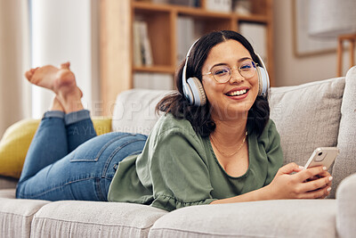 Buy stock photo Woman, portrait and headphones with smartphone on sofa, for hearing radio, online subscription and podcast. Happy female person listening to music, streaming audio and sound on mobile in living room