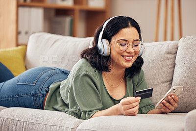 Buy stock photo Woman, credit card and phone on sofa, home and headphones with smile, online shopping or payment on web. Girl, smartphone and fintech app for cybersecurity, discount and deal with e commerce store