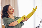 Woman, hand and gloves for cleaning service in home for safety from germs, bacteria in living room. Happy, girl and disinfect in apartment for dirt with for household maintenance for dust or virus.