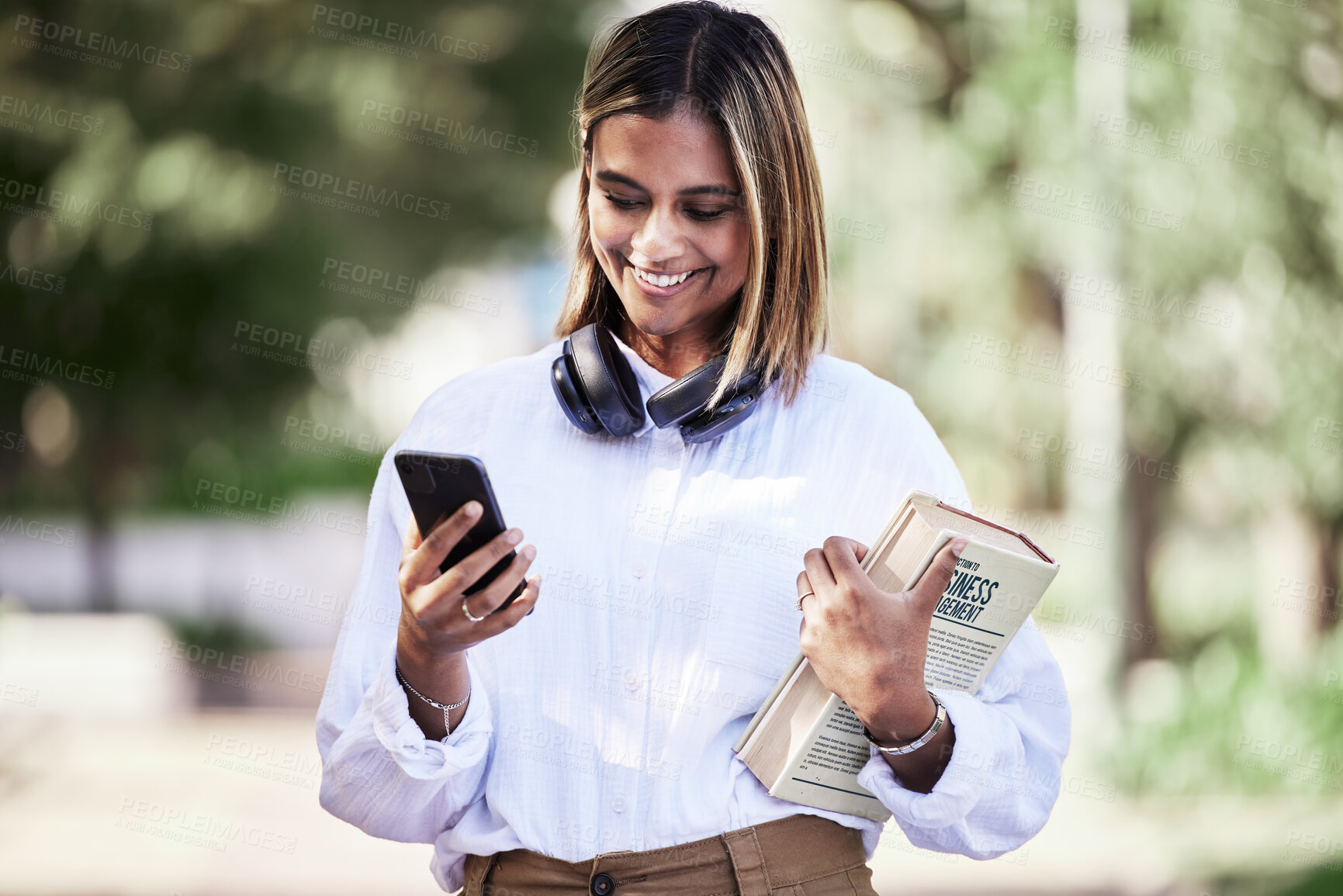 Buy stock photo Woman, phone or student with books in park outdoor for communication, music or chat. Social media, research and a happy young female person in campus nature with a smartphone connection and education