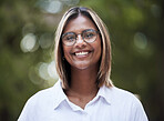 Portrait, smile and glasses with a woman in nature, outdoor on a green background for travel or freedom. Face, eyewear and a happy young female person standing in a park for vision or eyesight